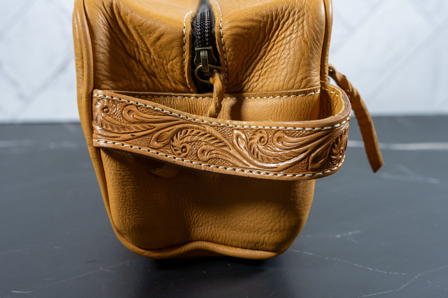 Hand-tooled cowhide toiletry travel bag, detail view