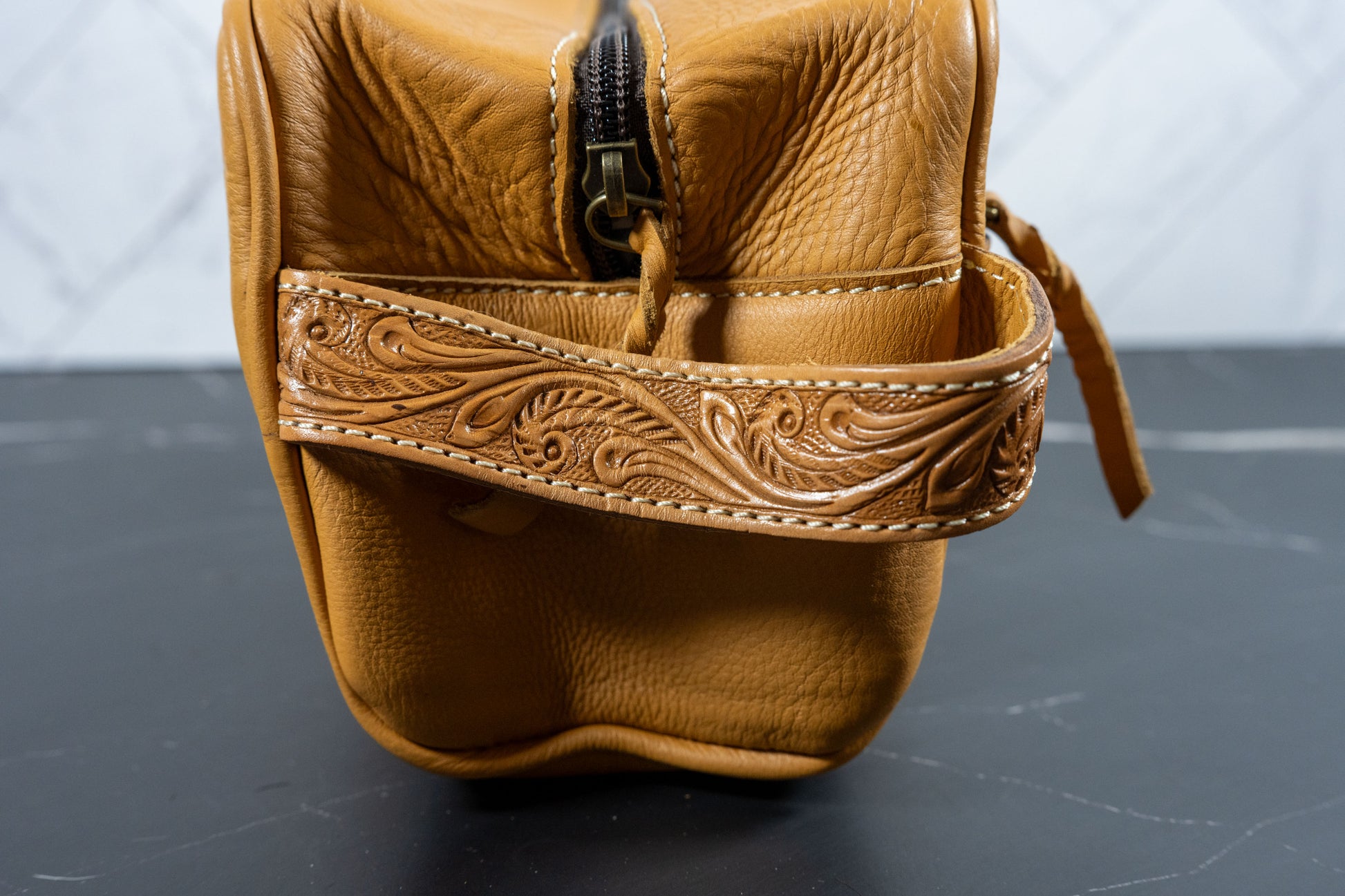 Hand-tooled cowhide toiletry travel bag, detail view